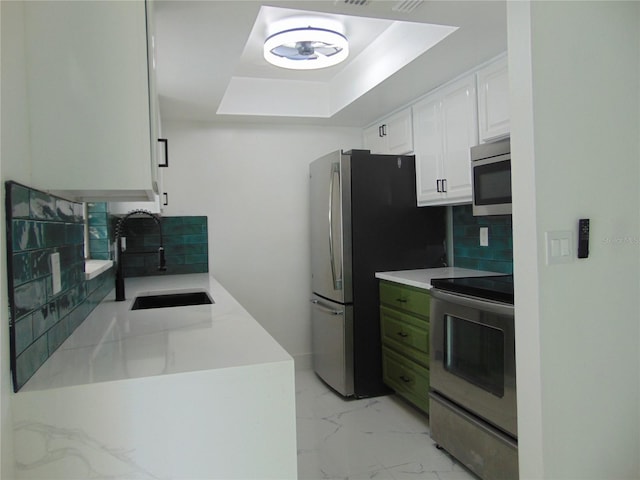 kitchen with white cabinets, sink, stainless steel appliances, and tasteful backsplash