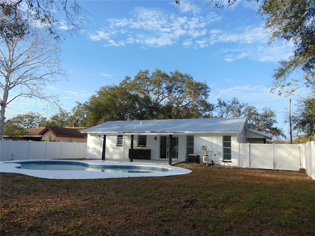 back of property featuring a fenced in pool and central air condition unit