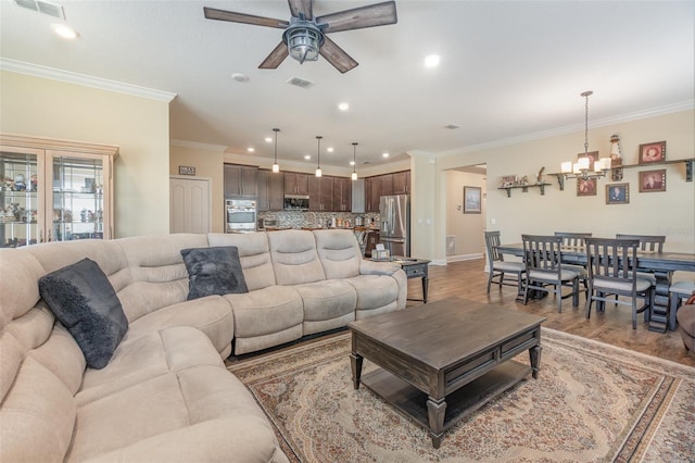 living room featuring crown molding, ceiling fan with notable chandelier, and hardwood / wood-style flooring