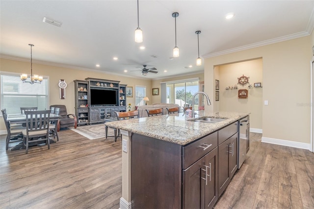 kitchen with ceiling fan with notable chandelier, hardwood / wood-style flooring, stainless steel dishwasher, and sink