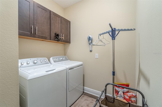 laundry room featuring cabinets and washer and clothes dryer