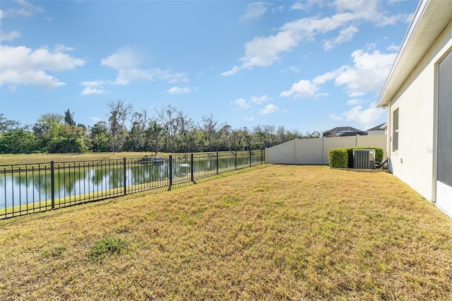 view of yard featuring central AC and a water view