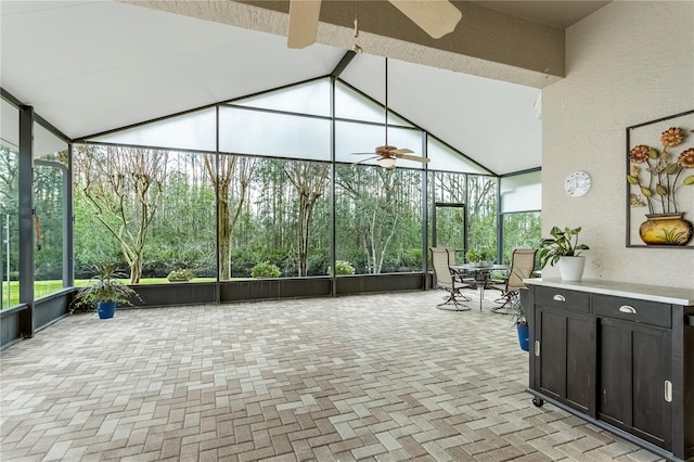 sunroom / solarium with ceiling fan, vaulted ceiling with beams, and a healthy amount of sunlight