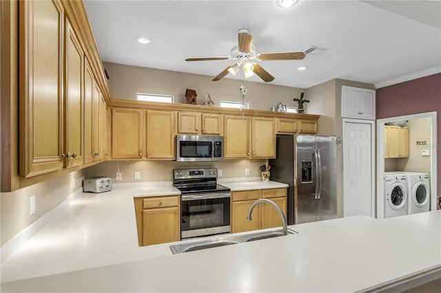 kitchen featuring sink, appliances with stainless steel finishes, kitchen peninsula, and washing machine and clothes dryer