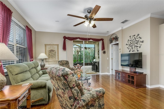 living room with ceiling fan, wood-type flooring, and ornamental molding