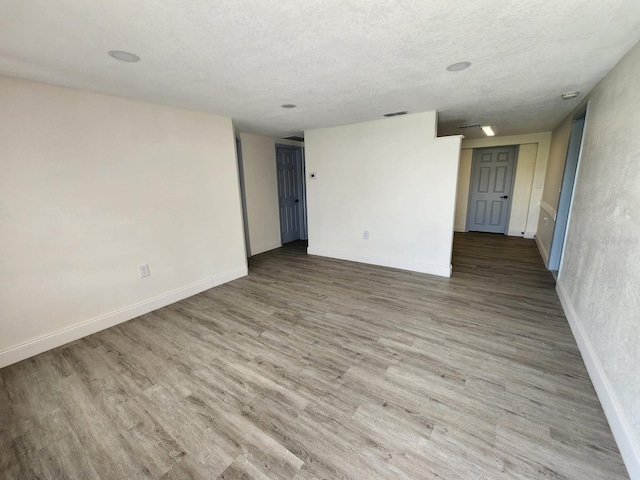 empty room featuring wood-type flooring and a textured ceiling