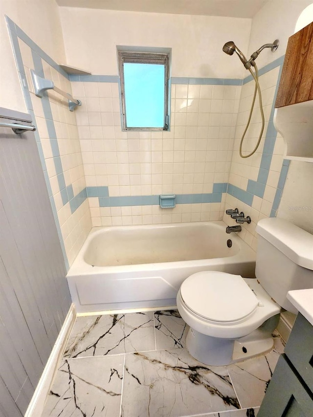 full bathroom with tiled shower / bath combo, toilet, and vanity