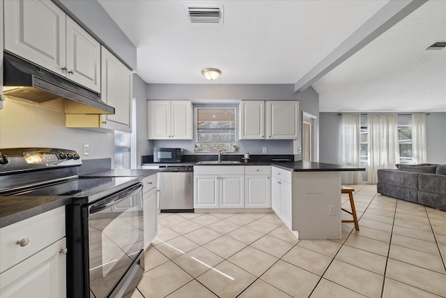 kitchen with a breakfast bar area, white cabinetry, light tile patterned floors, and stainless steel appliances