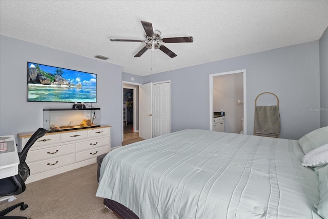 carpeted bedroom with ceiling fan, a closet, and a textured ceiling