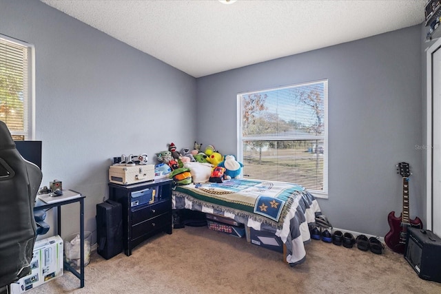 bedroom with light colored carpet and a textured ceiling