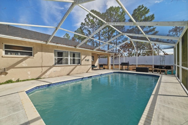 view of swimming pool with glass enclosure and a patio area