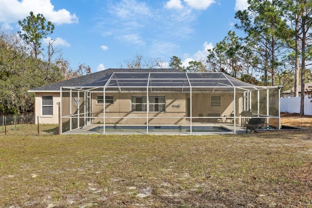 rear view of property with a lawn and glass enclosure