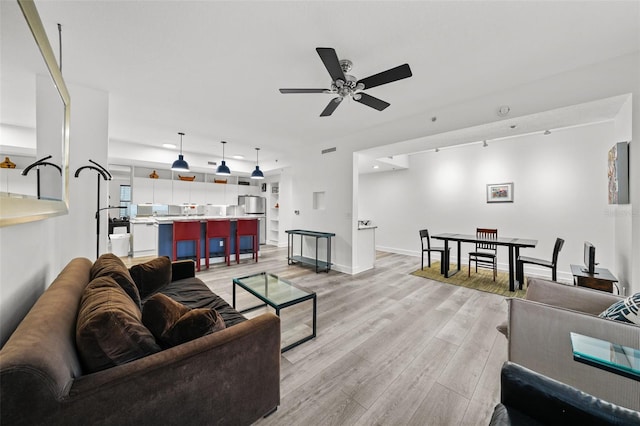 living room with ceiling fan and light wood-type flooring