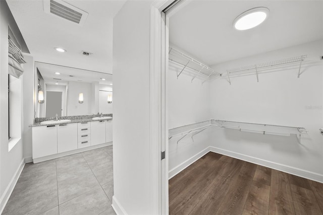 walk in closet featuring light hardwood / wood-style floors and sink