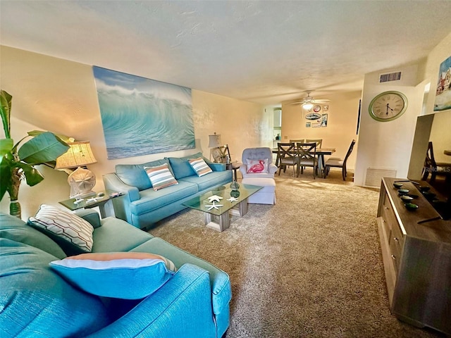 living room with ceiling fan and carpet