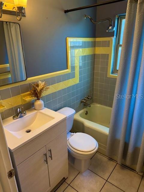 full bathroom with shower / bath combination with curtain, tasteful backsplash, vanity, tile patterned flooring, and toilet