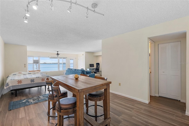 dining room featuring ceiling fan, hardwood / wood-style floors, and a textured ceiling