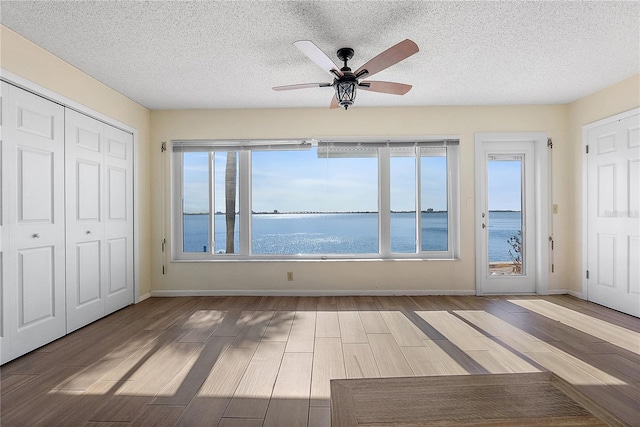 interior space with ceiling fan and a water view