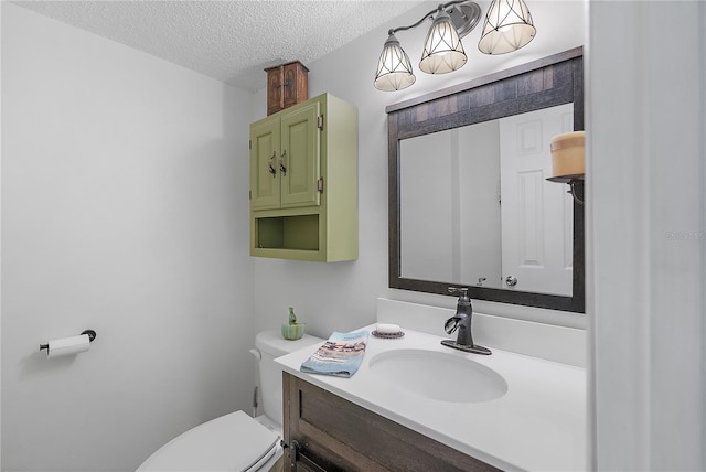 bathroom featuring toilet, a textured ceiling, and vanity