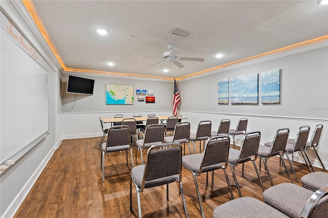 cinema with ornamental molding, dark wood-type flooring, and ceiling fan