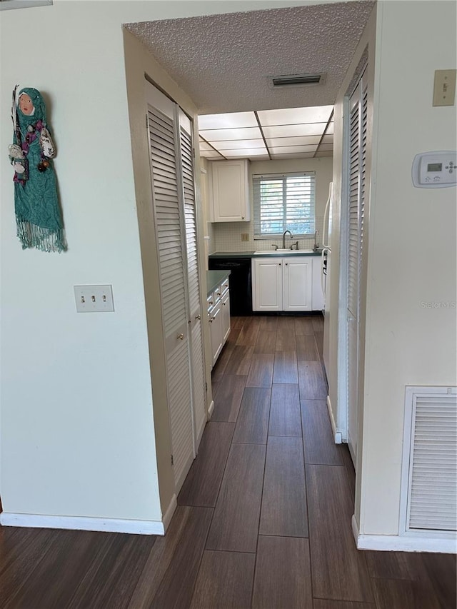 kitchen with dark wood finished floors, baseboards, visible vents, and white cabinetry