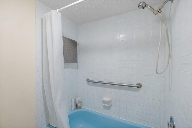 bathroom featuring shower / bathtub combination with curtain and a textured ceiling