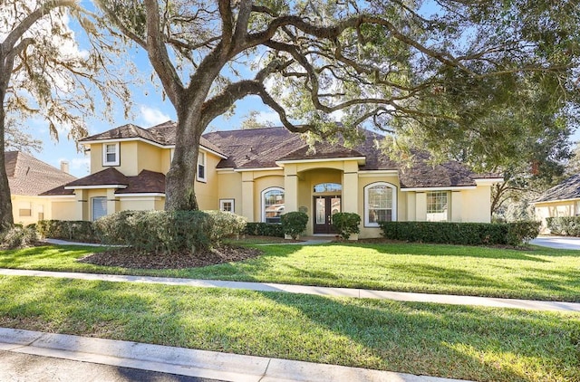 mediterranean / spanish home with a front lawn