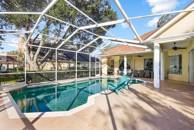 view of swimming pool with a patio area, ceiling fan, and glass enclosure