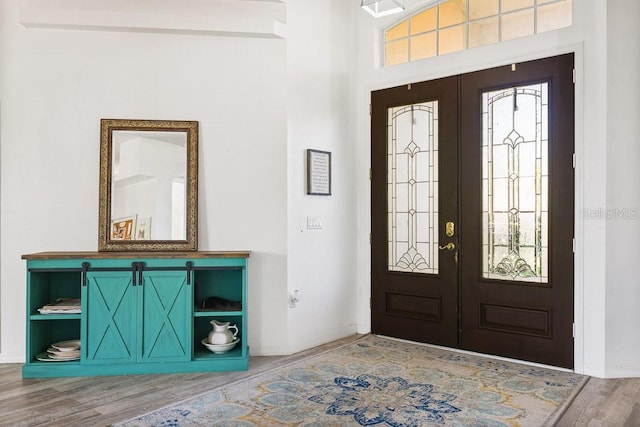 foyer featuring hardwood / wood-style flooring, a healthy amount of sunlight, and french doors