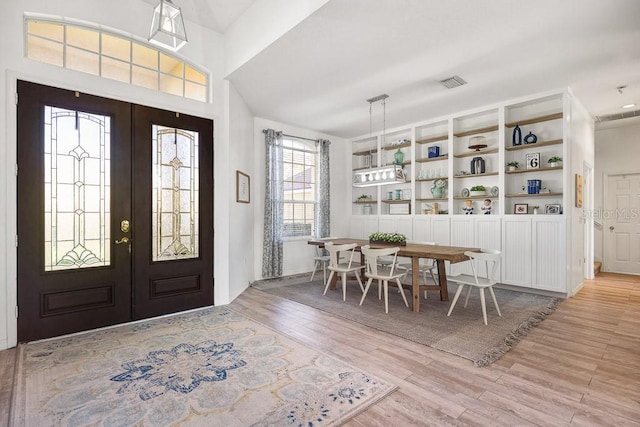 foyer entrance with french doors and light hardwood / wood-style floors