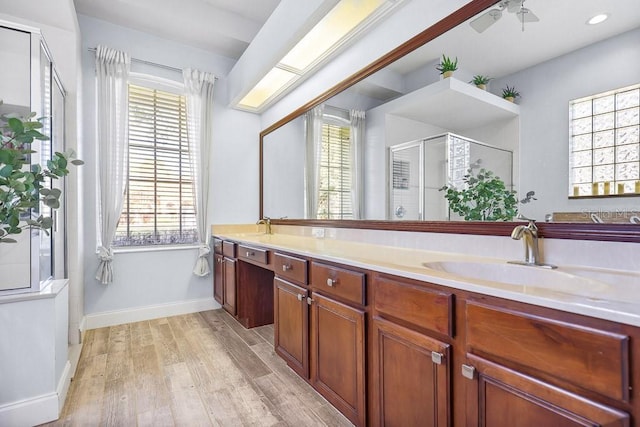 bathroom featuring hardwood / wood-style floors, vanity, ceiling fan, and a shower with shower door