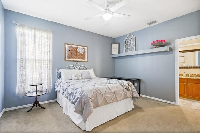 carpeted bedroom featuring connected bathroom and ceiling fan