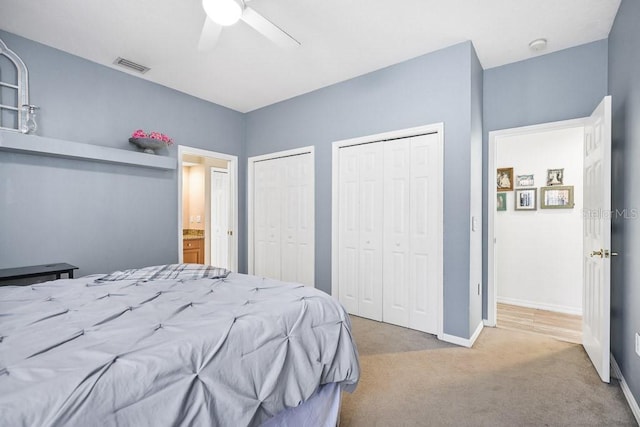 carpeted bedroom featuring ceiling fan and two closets