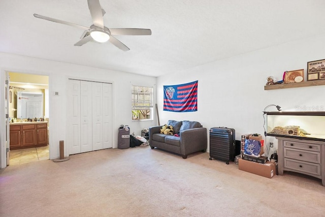 sitting room featuring ceiling fan and light carpet