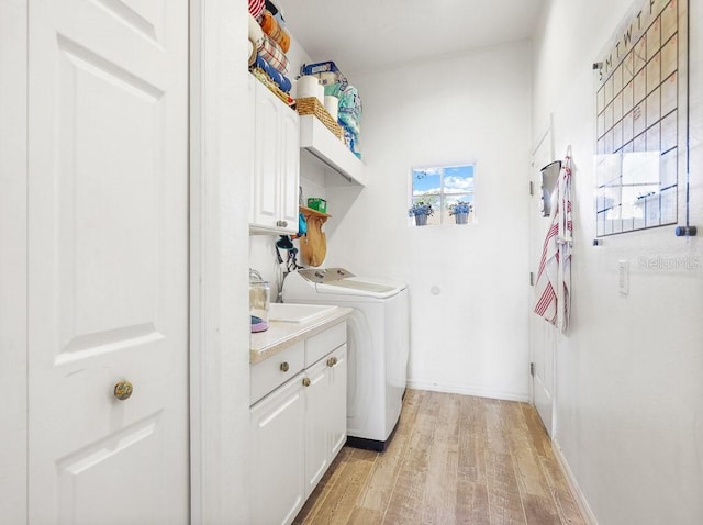 laundry room with cabinets, separate washer and dryer, and light hardwood / wood-style flooring