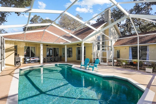 view of swimming pool with a lanai, a patio area, and ceiling fan