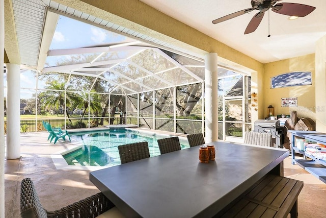 view of swimming pool with glass enclosure, ceiling fan, and a patio area