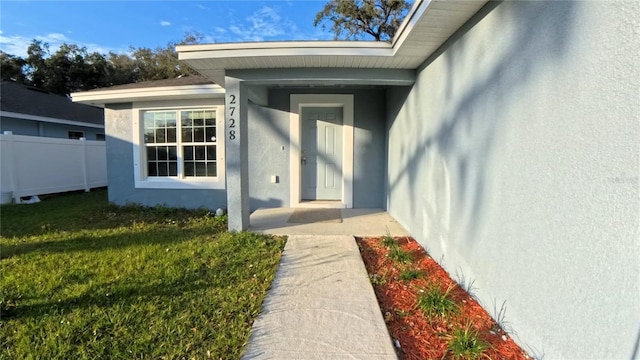 entrance to property with a lawn