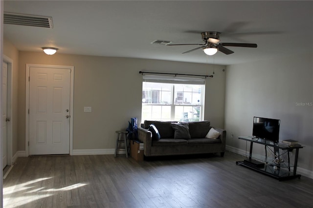 living room with ceiling fan and dark wood-type flooring