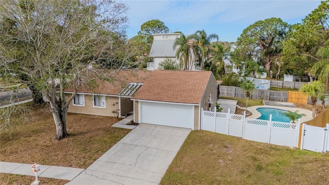 view of front of property featuring a garage, a fenced in pool, and a front yard