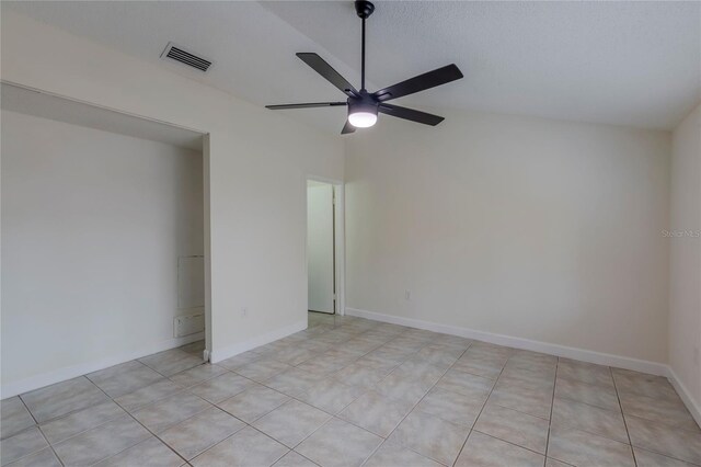 tiled empty room featuring ceiling fan and vaulted ceiling