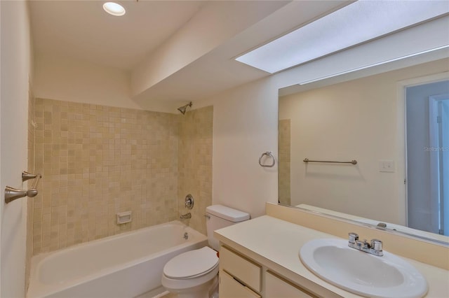 full bathroom featuring vanity, tiled shower / bath, and toilet