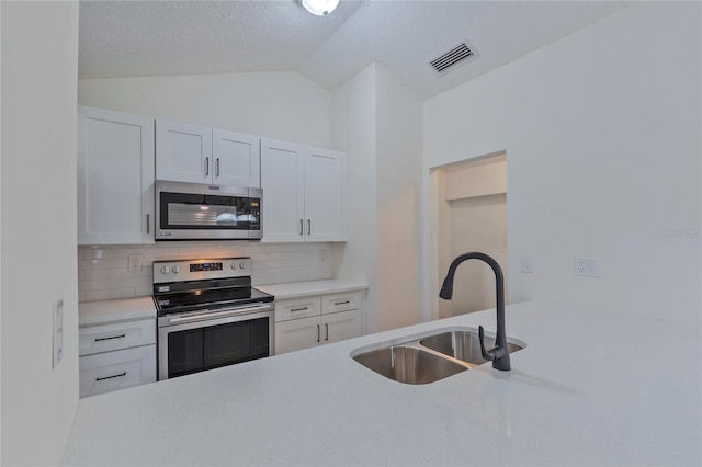 102 Shoreview Ln, Oldsmar, FL 34677 - kitchen featuring appliances with stainless steel finishes, a sink, light countertops, tasteful backsplash, and vaulted ceiling