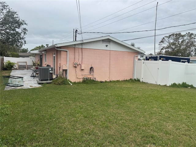 back of property featuring central AC unit, a patio, and a lawn