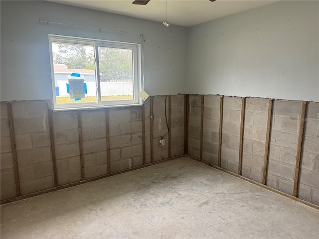 unfurnished room featuring ceiling fan and concrete floors