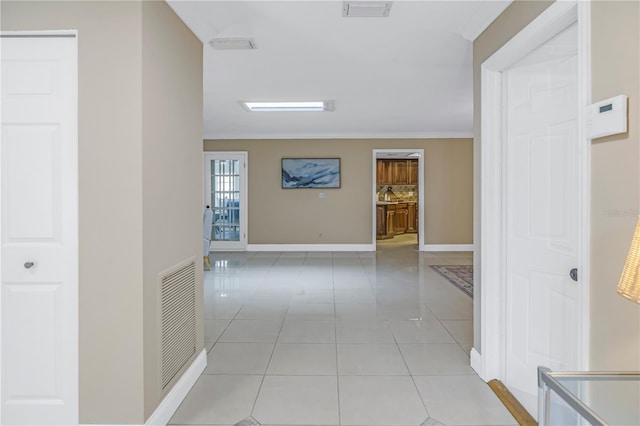 hallway featuring crown molding and light tile patterned floors