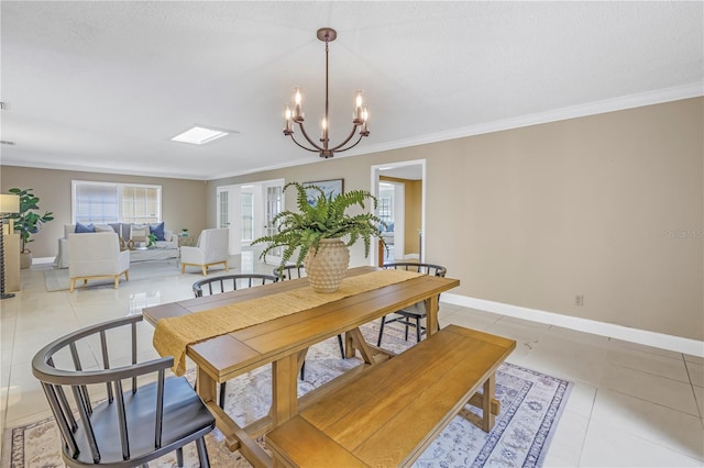 tiled dining space with a textured ceiling, an inviting chandelier, and crown molding