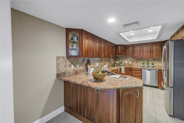 kitchen featuring sink, light tile patterned floors, light stone counters, kitchen peninsula, and stainless steel appliances