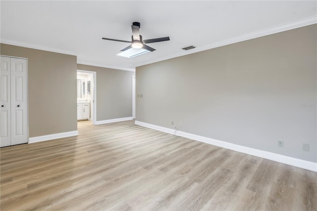 unfurnished bedroom with ceiling fan, ornamental molding, connected bathroom, light hardwood / wood-style floors, and a closet