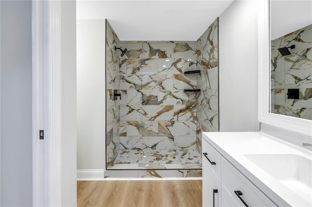 bathroom with a shower, hardwood / wood-style floors, and vanity